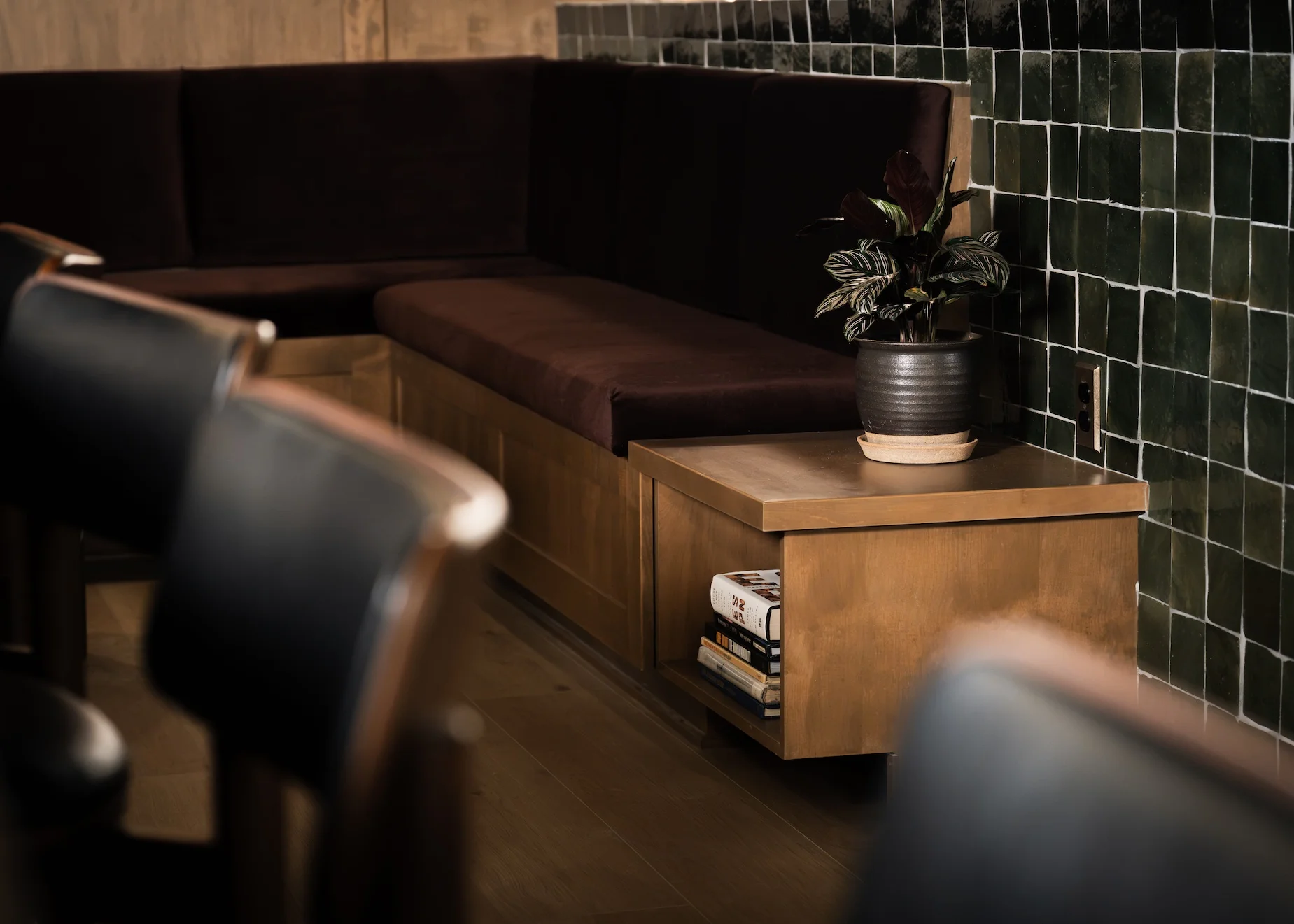 Lounge seating with burgundy banquette and green tile wall